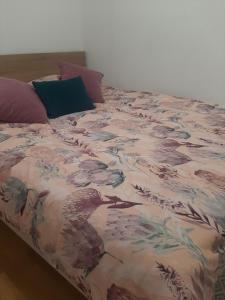 a bed with a blanket with a bird on it at Luxury Lamela Bulevar in Sarajevo