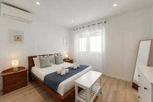 a bedroom with a bed with two towels on it at Baleal Blue Sky in Ferrel