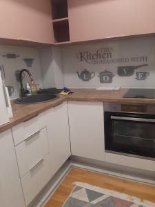 a kitchen with a sink and a stove top oven at Luxury Lamela Bulevar in Sarajevo