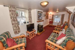 ein Wohnzimmer mit Sofas und einem Flachbildfernseher in der Unterkunft Last-Minute Escapes l Sleeps Up to 4 l A delightful thatched cottage with all the modern facilities you will require l There are 2 bedrooms, one with a double bed l the other with two singles l Carrick Thatched Cottage l WeStayBelfast in Eden