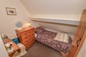 ein kleines Schlafzimmer mit einem Bett und einer Kommode in der Unterkunft Last-Minute Escapes l Sleeps Up to 4 l A delightful thatched cottage with all the modern facilities you will require l There are 2 bedrooms, one with a double bed l the other with two singles l Carrick Thatched Cottage l WeStayBelfast in Eden