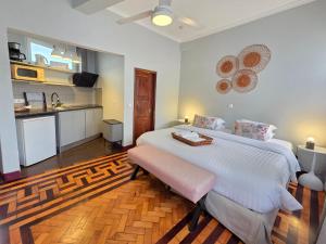 a bedroom with a large bed and a kitchen at ASPA Studios - Urban Conscious Living in Funchal
