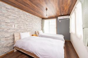 two beds in a room with a brick wall at Y's INN Tsutusji 014T in Tokyo +101 photos