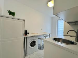 a kitchen with a washing machine and a sink at Cosmopolis - Anturium Studio in Gara Pantelimon