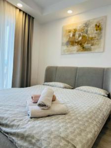 a bedroom with a bed with towels on it at Cosmopolis - Anturium Studio in Gara Pantelimon