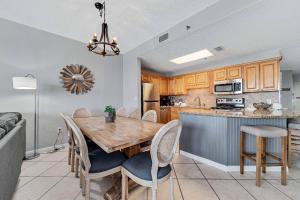 Una cocina y un comedor con mesa y sillas de madera. en Phoenix V 1105, en Orange Beach