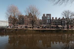 a row of buildings next to a river at Adam's Canal House in Amsterdam
