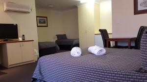 A bed or beds in a room at Gateway Motor Inn - Self Check-In