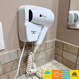 a hair dryer in a bathroom with a phone at Le Jardin - Temporada CN - Adriele in Caldas Novas