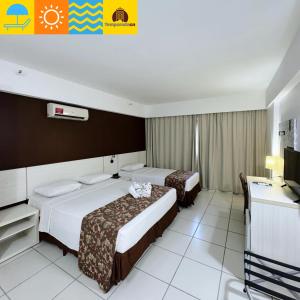 a hotel room with two beds and a television at Le Jardin - Temporada CN - Adriele in Caldas Novas