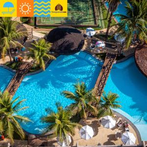 an overhead view of a resort swimming pool with palm trees at Le Jardin - Temporada CN - Adriele in Caldas Novas