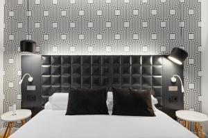 a bedroom with a bed with a black headboard and two tables at B&B HOTEL Tarragona Valls in Valls +56 photos