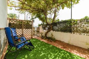a yard with a blue chair sitting on the grass at Villa Grace Amalfi seaview Jacuzzi in Amalfi