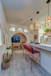 a kitchen with two red chairs and a counter at Apartamento Studio Grécia - Ondina in Salvador