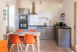 a kitchen with a table and orange chairs at T3 Duplex dépendance du Château in Gennes
