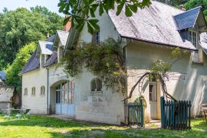 an old white house with a black fence at T3 Duplex dépendance du Château in Gennes