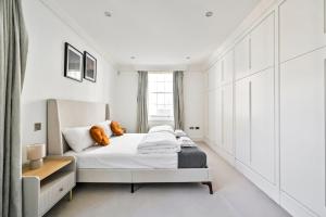 a white bedroom with a bed and a window at Spacious Fitzrovia Apartment 3 Bed in London