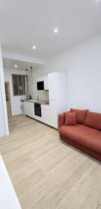 a living room with a red couch and a kitchen at Catel Studio hyper centre Saint Dizier in Saint-Dizier