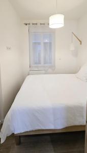 a white bed in a room with a window at Catel Studio hyper centre Saint Dizier in Saint-Dizier