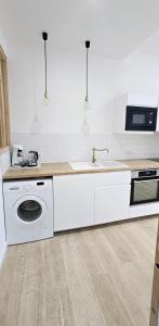 a white kitchen with a sink and a dishwasher at Catel Studio hyper centre Saint Dizier in Saint-Dizier +22 photos