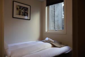 a white bed in a room with a window at Dinbnb Apartments I Charming 3-Bedroom in the Heart of the City in Bergen