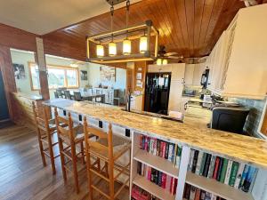 een keuken met een aanrecht met stoelen en een bar met boeken bij SN9615- Byrd's Nest in Nags Head