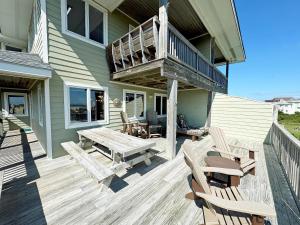 een terras met een tafel en stoelen op een huis bij SN9615- Byrd's Nest in Nags Head