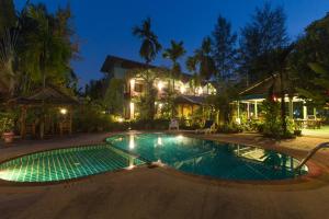 uma piscina em frente a uma casa à noite em Ladda Resort em Khao Lak