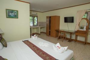 um quarto com uma cama com duas cabeças de gato em Ladda Resort em Khao Lak