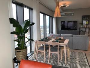 un salon avec une table, des chaises et une plante en pot dans l'établissement Spacious corner apartment with sea view, à Helsinki 5 autres photos