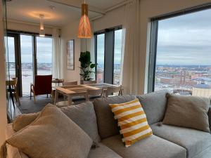 un salon avec un canapé et une table dans l'établissement Spacious corner apartment with sea view, à Helsinki