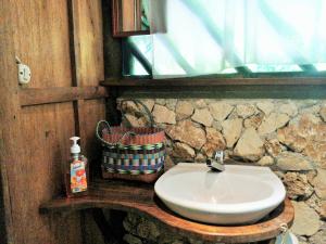 a bathroom with a white sink and a window at El Hotelito Perdido in Río Dulce