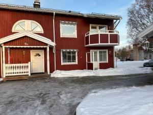 a red house with a white door in the snow at Amerikavägen 9 in Skellefteå