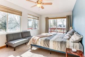 a bedroom with a bed and a couch and windows at Ice Fish, Hunt and Explore Farwell Home on Lake in Farwell