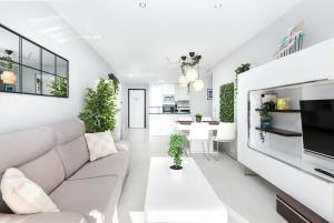a living room with a couch and a tv at Luxury Seaview Beachfront Apartment Pools,Jacuzzi,Gym in Arenales del Sol