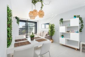 a white living room with a table and chairs at Luxury Seaview Beachfront Apartment Pools,Jacuzzi,Gym in Arenales del Sol