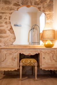a wooden dresser with a mirror and a stool at Gravel Aegina House in Aegina