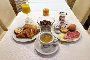 a table with a plate of breakfast food and a cup of coffee at Hôtel du Mont Blanc in Paris