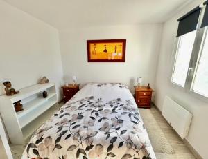 a bedroom with a bed with a floral bedspread at ANNE - Maisonnette confortable avec Cour privée à Berck-Plage in Berck-sur-Mer +4 photos