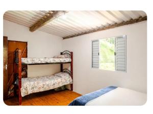 a bedroom with two bunk beds and a window at Chalé Foroni in Cunha