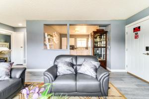 sala de estar con sofá de cuero y espejo en 11 Mi to Kincaid Park Convenient and Cozy Apt!, en Anchorage