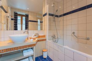 a bathroom with a sink and a shower and a tub at Hôtel Le Bois Joli in Cauterets +144 photos