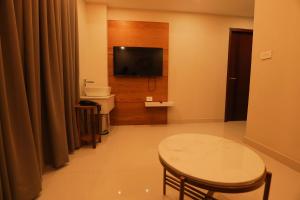 コーリコードにあるHotel Bluebellのテレビ、テーブル、トイレ付きのバスルーム