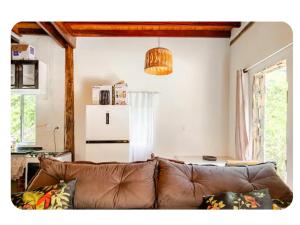 a living room with a brown leather couch at Chalé Foroni in Cunha +27 photos