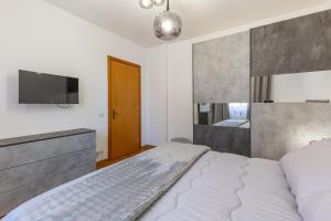 a bedroom with a bed and a flat screen tv at Il Cammino in San Quirico dʼOrcia