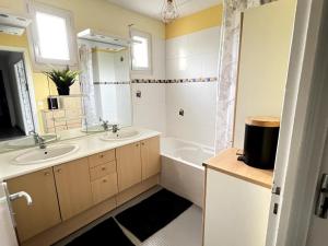 a bathroom with two sinks and a bath tub at maison familiale 14 personnes in Les Ponts-de-Cé +20 photos