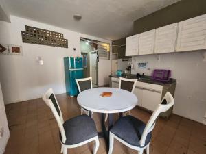 a kitchen with a table and chairs and a refrigerator at Casa do Meio Pousada in Recife