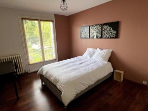 a bedroom with a large bed with white sheets at maison familiale 14 personnes in Les Ponts-de-Cé