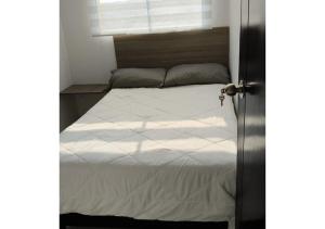 a bedroom with a large white bed with a window at Apartamento nuevo 3 habitaciones 6 personas - Cerca a Expoferias y Bosque Popular in Manizales