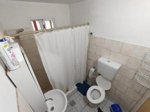 Un baño con inodoro y cortina de ducha. en Cabaña ParaLelo 1, en Viedma 36 fotos más